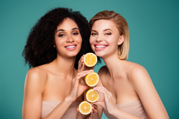 照片中快乐的女孩抱在一起的三片水果片孤立的青色背景图片下载