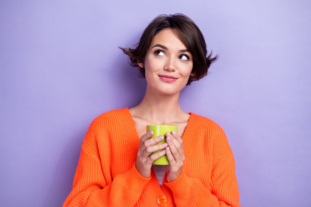 可爱的梦幻女士的照片，穿着时髦的衣服，拿着香气茶，看横幅，主张在紫色的背景上孤立的空白空间图片下载