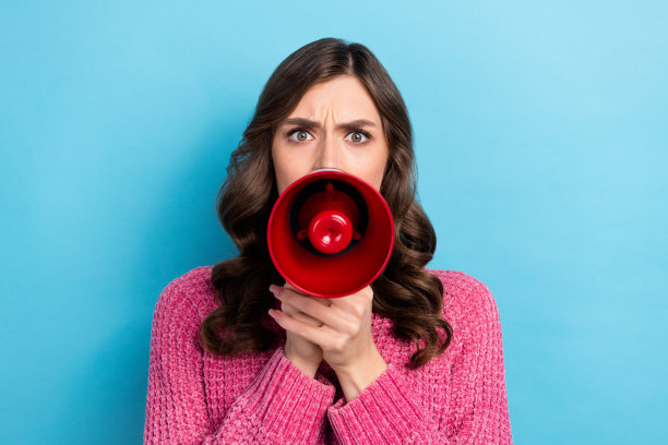 照片中的年轻进取、专横、有吸引力的企业家女士拿着扩音器尖叫，声音已经失去了注意力，孤立在蓝色的背景上图片下载