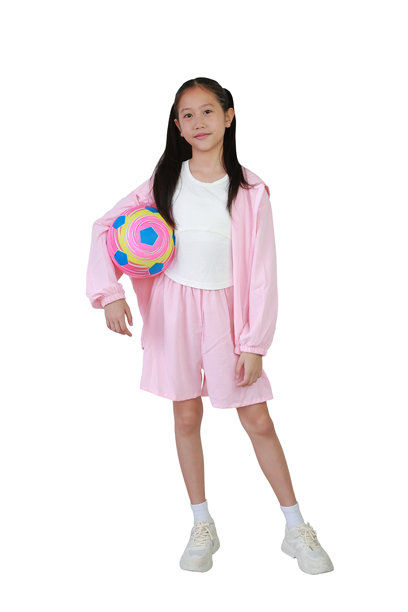 身穿粉色运动服的亚洲女孩站在白色背景上，手里拿着足球。全身照片与剪辑路径。图片下载