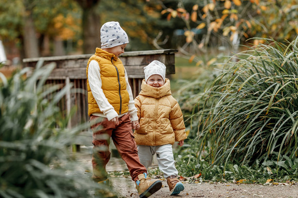 快乐的孩子们在秋天的公园里。鲜艳的秋色。图片下载