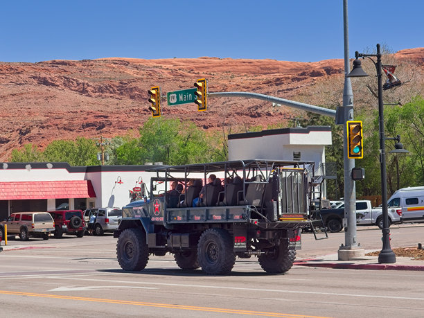 崎岖的越野车与导游和游客沿主要街道在市区摩押图片下载