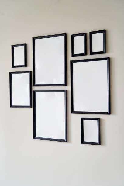 灰色的墙上挂着大小不一的相框照片。模型。图片下载