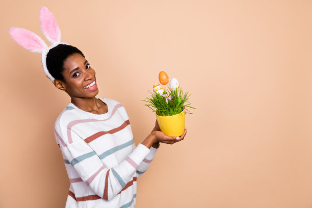 照片可爱梦幻的中性人穿毛衣兔子头带上升复活节锅空空间孤立米色背景图片下载