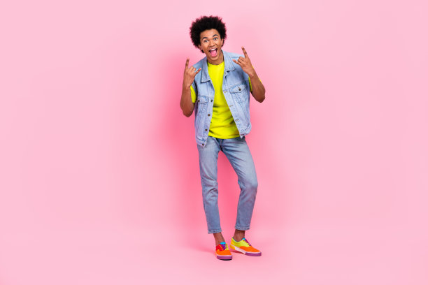 全身照片喜出望外的高兴的男人穿着时髦的衣服，听音乐，摇滚，有乐趣的喜悦孤立在粉红色的背景图片下载