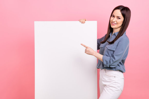 照片正面可爱的女士穿着时髦的灰色衣服手臂直接空空间低价格主张孤立在粉红色的背景图片下载