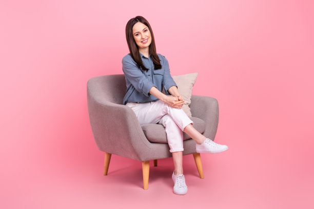 坐着舒适扶手椅的全身照片商务女性宿舍放松午餐时间办公室经理休息孤立在粉红色的背景图片下载