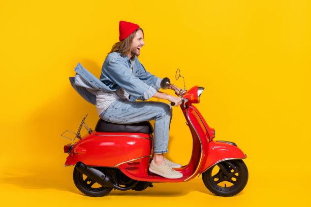 全长照片正面印象深刻的男人穿牛仔看起来空旷的空间骑摩托车孤立的黄色背景图片下载