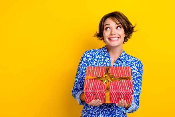 时髦的梦幻女士的照片穿印花衬衫得到红色的礼品包看起来空的空间孤立的黄色背景图片下载