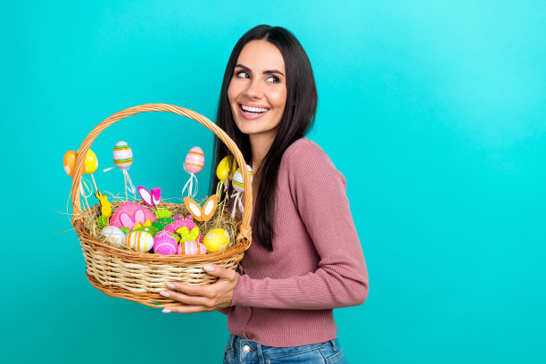 照片的梦幻可爱迷人的女士穿着粉红色的衬衫拿着桶与画彩蛋复活节假期看起来空的空间孤立的蓝色背景图片下载