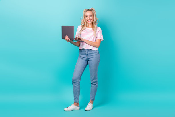 华丽的正面女士的全身照片持有使用无线上网本孤立的绿松石色背景图片下载