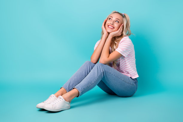 乐观梦想的女人的全尺寸照片波浪发型条纹t恤坐在看空空间孤立在明亮的蓝绿色背景图片下载