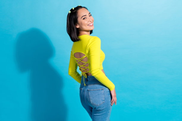 自信迷人的年轻人别致的照片穿着时尚的魅力装打开脊柱露脐上衣夜总会服装孤立的蓝色背景图片下载