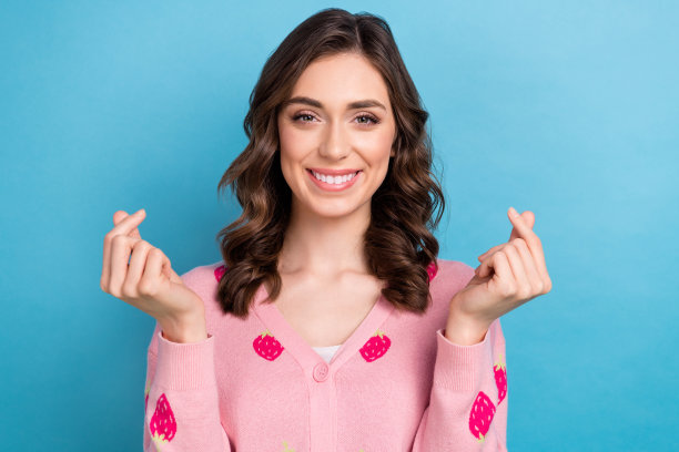 照片肖像迷人的女人显示韩国心脏标志穿着时尚的粉红色草莓印花服装孤立的蓝色背景图片下载