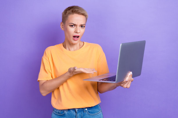 印象深刻的不满意的女孩的肖像显示上网本孤立的紫色背景图片下载