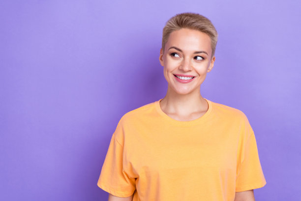 可爱的白色头发的肖像照片年轻的女孩微笑着穿着橙色的t恤看起来感兴趣的空白空间宣传孤立在紫色的背景图片下载