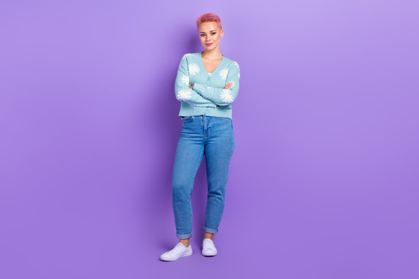 自信女孩的全身照片，双手合抱，穿着时尚的衣服，印花雏菊开衫，在紫罗兰色的背景上享受孤独的衣服图片下载