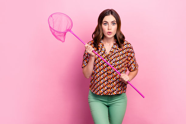 年轻积极的照片喜出望外疯狂的女人爱好抓蝴蝶抱网噘嘴惊讶意外孤立在粉红色的背景图片下载