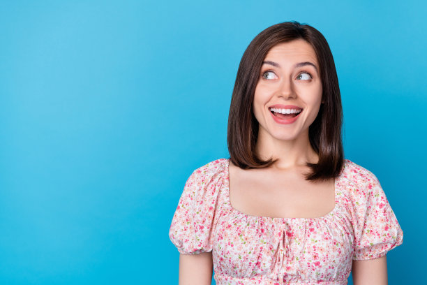 特写照片年轻迷人可爱的漂亮女人穿着花衬衫兴奋地看空空间和孤立的蓝色背景图片下载