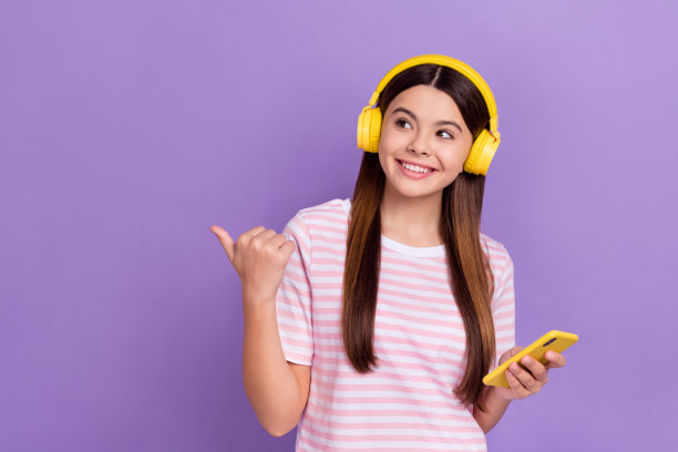 照片中闪亮梦幻的女孩穿着条纹t恤享受歌曲现代小工具拇指空白空间孤立的紫色背景图片下载