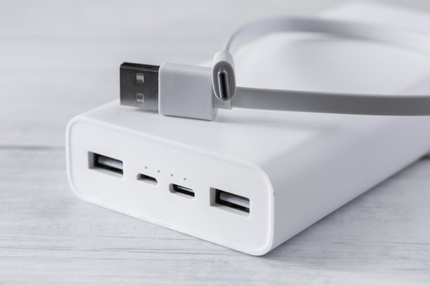 白色移动电源，为智能手机和各种数字设备充电，白色木制背景图片下载