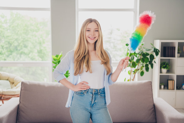 照片积极的好心情的女孩穿着蓝色衬衫在室内做家务的房子公寓房间图片下载