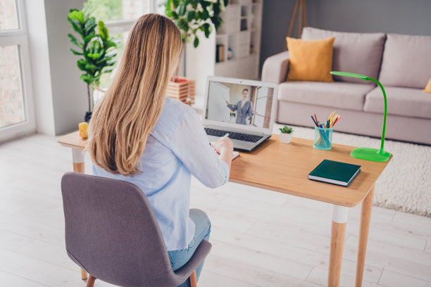 漂亮女士穿着休闲衬衫的照片，距离放大在室内学习现代设备图片下载