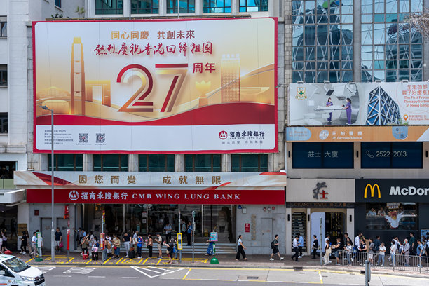 一条繁忙的香港街道，有招商永隆银行分行和各种商店和招牌。图片下载