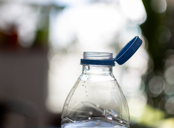 特写照片显示了一个塑料瓶口，瓶盖嵌入其中，无法与瓶子分开图片下载