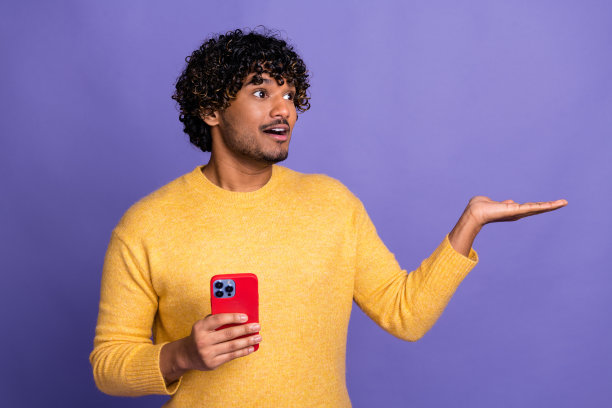 照片上的模特男人穿着时髦的衣服，手臂抱着新奇的空间，孤立在紫色的背景上图片下载