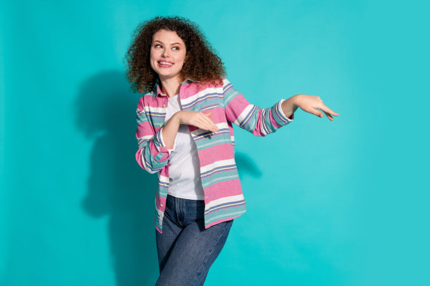 照片肖像卷发美丽迷人年轻的黑发女士跳舞动人听音乐孤立的海蓝宝石色背景图片下载