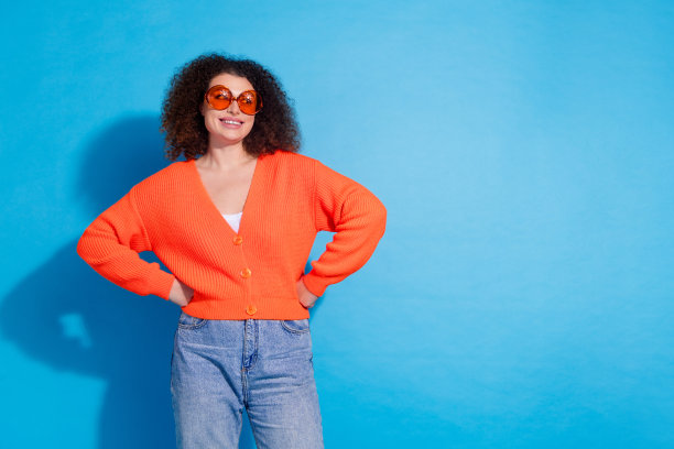 照片肖像卷曲的雪佛兰头发拉丁模特妇女游客戴着尝试新的模式时尚太阳镜孤立的蓝色背景图片下载