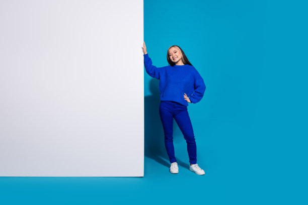 时尚韩国女孩的照片肖像附近的手机显示营销演示下载更新的应用程序孤立的蓝色背景图片下载