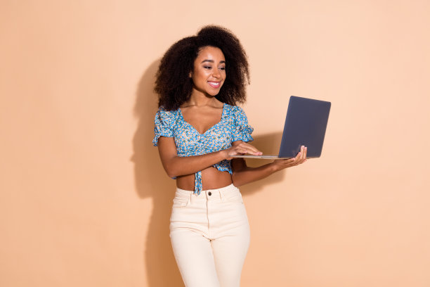 照片中可爱可爱的女孩穿着蓝色上衣打字苹果三星现代设备空白空间孤立米色背景图片下载