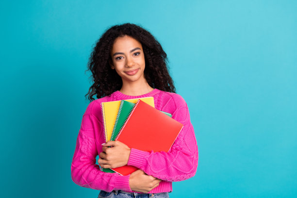 照片肖像可爱的少女女士拿着课本教育穿着时尚的粉红色服装孤立的青色背景图片下载