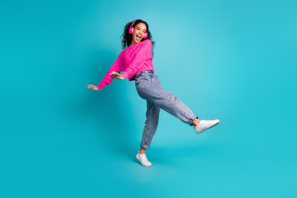 完整的照片可爱的少女跳舞耳机穿着时尚的粉红色服装孤立的青色背景图片下载