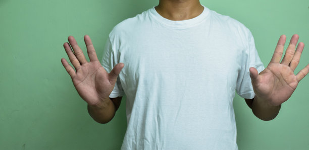 年轻的聋哑人在绿色背景上使用手语图片下载