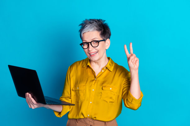 照片中，一个非常开朗的女人戴着衬衫眼镜，用现代设备发短信，背景是v字和孤立的蓝色图片下载