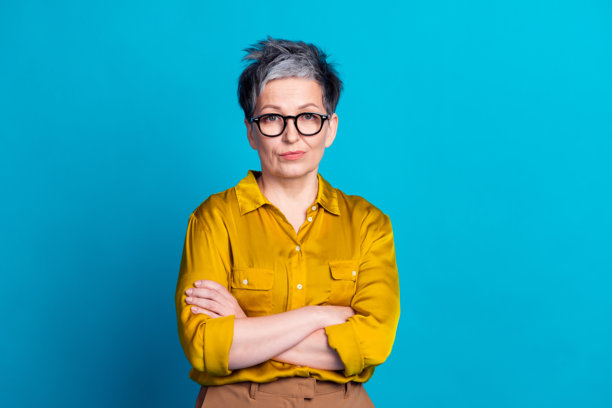 照片中可爱的好心情的女士穿着衬衫眼镜双臂折叠空空间孤立的蓝色背景图片下载