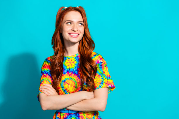 漂亮的年轻女孩的照片肖像交叉双手看起来空的空间穿时髦的彩色服装孤立的海蓝宝石色背景图片下载