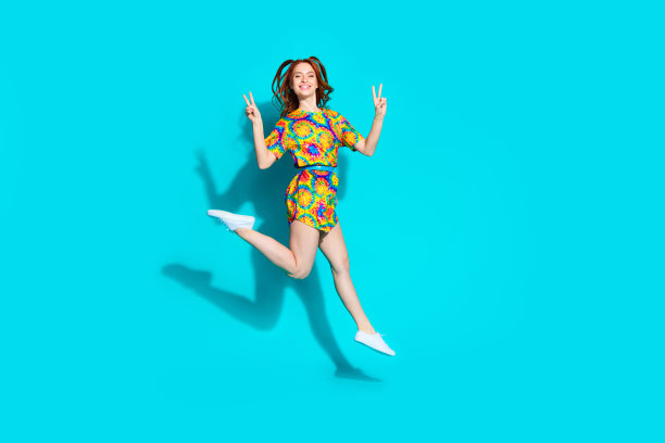 漂亮的年轻女孩的全尺寸照片跳走v字穿时髦的彩色服装孤立的海蓝宝石色背景图片下载