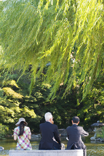 京都丸山公园里的一对男女坐在长凳上图片下载