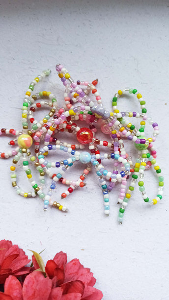 桌子上放着一串珠子，还有用珠子做成的手工丝带图片下载