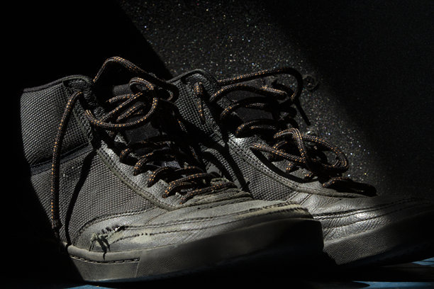 马可产品的照片，一双破旧的滑板鞋坐在戏剧性的灯光对抓地布的背景。图片下载