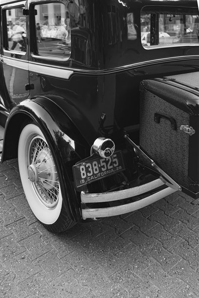 1928年的加州车牌-斯图德贝克总统轿车，带有复古的后行李箱-咆哮的20世纪20年代的精神。黑白垂直照片。图片下载
