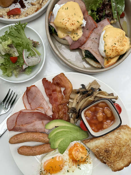 白色盘子上的炸早餐照片，一碗配生菜、樱桃番茄和萝卜片的沙拉，一碗班尼迪克蛋，焦糖法式吐司，香草冰淇淋，草莓，切碎的杏仁，金属叉图片下载