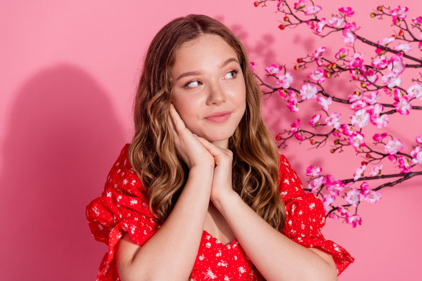照片肖像可爱的少女看起来空的空间梦幻般的樱花穿着时尚的红色服装孤立在粉红色的背景图片下载