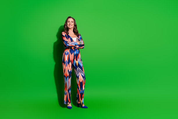 全身照片光泽迷人的女士穿着五颜六色的衣服手臂折叠空空间孤立绿色背景图片下载