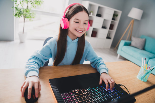 照片开朗积极可爱的女孩小玩家玩在线视频游戏的家庭房间室内图片下载