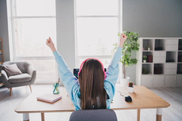 后面的照片可爱可爱的女孩举起手玩在线游戏的玩家在房子里图片下载